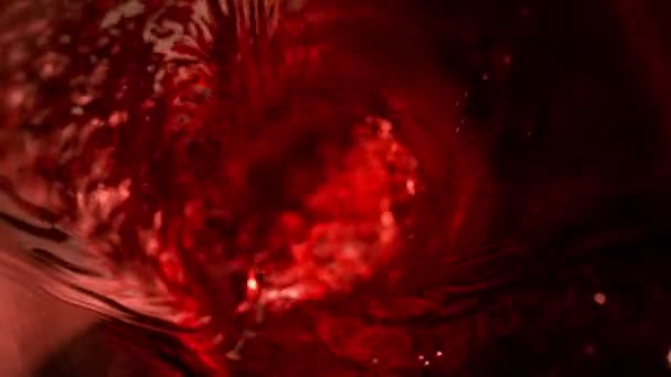 Mouvement super lent de verser du vin rouge en forme de tornade. Filmé sur caméra de cinéma à grande vitesse, 1000 images par seconde.