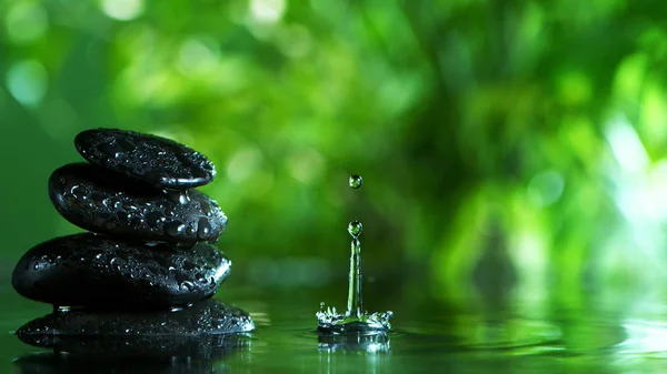 Dripping drops of water with black lava stones Royalty Free Stock Photos