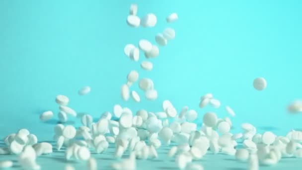 Супер Повільний Рух Падаючих Білих Таблеток Синьому Фоні Знімається Високошвидкісній — стокове відео
