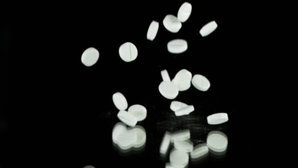 Superzeitlupe fallender weißer Pillen auf schwarzem Hintergrund. Gefilmt mit High-Speed-Kino-Zeitlupe, 1000fps.