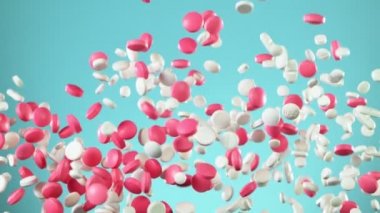 Mavi arka planda karışık hapların düşüşü çok yavaş. Yüksek hızlı sinema, yavaş çekim kamera, 1000fps.