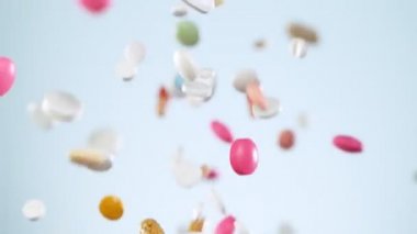 Beyaz arka plana düşen beyaz hapların süper yavaş çekimleri. Yüksek hızlı sinema, yavaş çekim kamera, 1000fps.