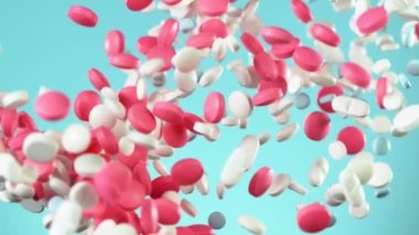 Mavi arka planda beyaz hapların düşüşü çok yavaş oluyor. Yüksek hızlı sinema, yavaş çekim kamera, 1000fps.