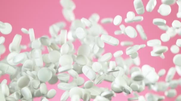 Super Cámara Lenta Caída Píldoras Blancas Sobre Fondo Rosa Filmado — Vídeos de Stock