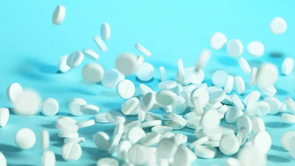 Freeze motion of flying pills on blue background — Stock Photo, Image
