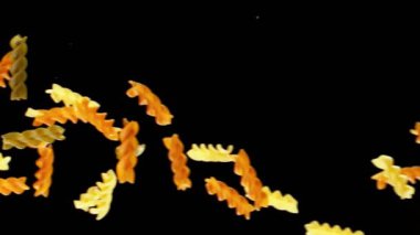 Siyah arka planda pişmemiş İtalyan makarnasının süper yavaş çekimi. Yüksek hızlı sinema kamerası, 1000 fps..