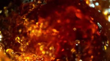 Super slow motion of pouring cola/whiskey or ice tea drink in twister shape. Filmed on high speed cinema camera, 1000 fps.