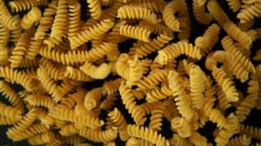 Süper yavaş çekimde pişmemiş İtalyan makarnası, siyah arka planda. Yüksek hızlı sinema kamerası, 1000 fps..