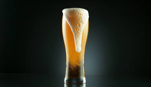 将啤酒倒入玻璃杯的冻结动作 在黑色背景下隔离 — 图库照片
