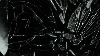 Siyah arka planda parçalanmış camların süper yavaş çekimleri. Yüksek hızlı sinema kamerası, 1000 fps..