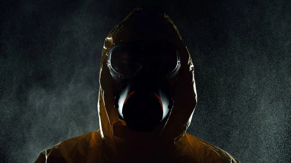 Portrait of a man in chemical suit with respirator and goggles. Concept of protection against viruses, biological attack or chemical pollution.
