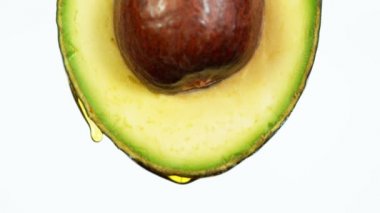 Avokado dilimine damlayan yağın süper yavaş akışı. Yüksek hızlı sinema kamerasıyla çekilmiş..