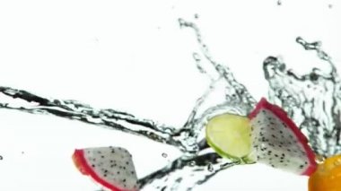 Su sıçramalı egzotik meyve dilimlerinin süper yavaş çekimi. Yüksek hızlı sinema kamerası, 1000 fps..