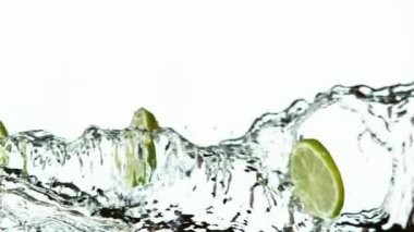 Beyaz arka planda su sıçraması olan limon dilimlerinin süper yavaş çekimi. Yüksek hızlı sinema kamerası, 1000 fps..