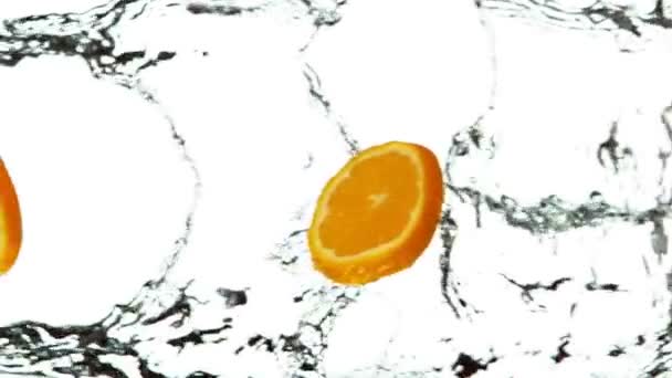 Super Slow Motion Van Sinaasappelschijfjes Met Waterspetters Witte Achtergrond Gefilmd — Stockvideo