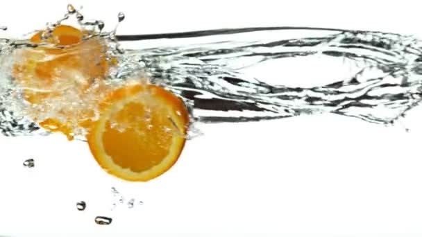 Super Slow Motion Orange Skivor Med Vatten Stänk Vit Bakgrund — Stockvideo