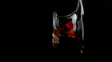 Viski ya da romun süper yavaş çekimi, siyah arka planda yakın plan detayı. Yüksek hızlı sinema kamerası, 1000fps