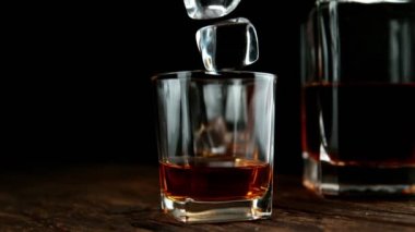 Buz küpünün viski içkisine dönüşmesi çok yavaş bir hareket, kamera hareketi. Yüksek hızlı sinema kamerası, 1000fps