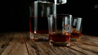 Buz küpünün viski içkisine dönüşmesi çok yavaş bir hareket, kamera hareketi. Yüksek hızlı sinema kamerası, 1000fps