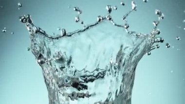 Mavi arkaplana su sıçratmanın süper yavaş akışı. Yüksek hızlı sinema kamerası, 1000fps.