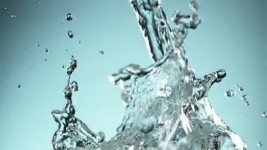 Mavi arkaplana su sıçratmanın süper yavaş akışı. Yüksek hızlı sinema kamerası, 1000fps.