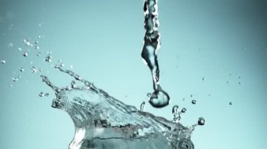 Mavi arkaplana su sıçratmanın süper yavaş akışı. Yüksek hızlı sinema kamerası, 1000fps.