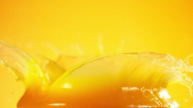 Renkli arka planda izole edilmiş süper yavaş portakal suyu sıçraması. Yüksek hızlı sinema kamerası, 1000 fps..