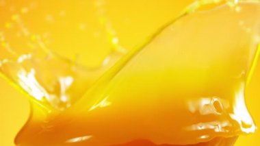 Renkli arka planda izole edilmiş süper yavaş portakal suyu sıçraması. Yüksek hızlı sinema kamerası, 1000 fps..