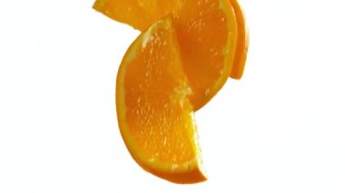 Süper yavaş çekimde portakal dilimleri beyazın üzerine dökülüyor. Yüksek hızlı sinema kamerası, 1000 fps..