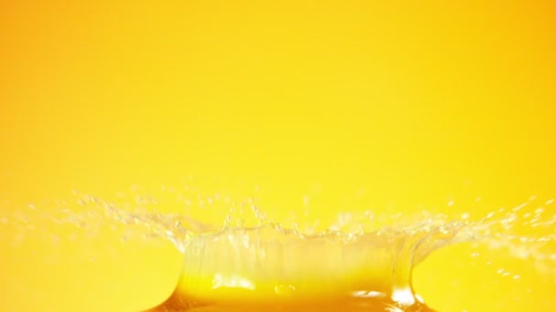 Mouvement super lent de la tranche d'orange tombant dans le jus. Filmé sur caméra de cinéma à grande vitesse, 1000 images par seconde.