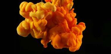 Suda soyut renkli mürekkep, siyah arkaplanda izole.