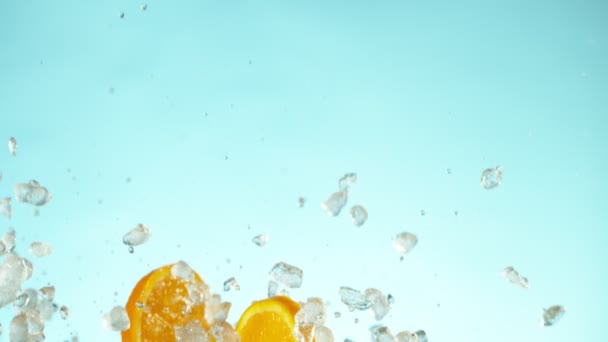 Super Zeitlupe Fallender Orangenscheiben Mit Crushed Ice Auf Blauem Hintergrund — Stockvideo