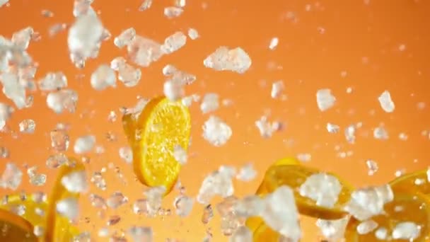 Super Powolny Ruch Spadających Plasterków Pomarańczy Kruszonym Lodem Niebieskim Tle — Wideo stockowe