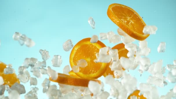 Супер Повільний Рух Оранжевих Скибочок Подрібненим Льодом Синьому Фоні Знімається — стокове відео