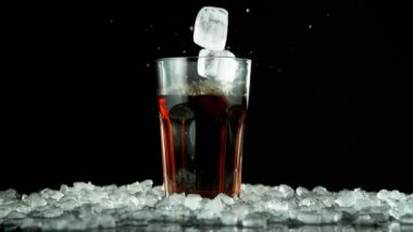 Buz küpünün kola içeceğine düşmesi çok yavaş bir hareket. Yüksek hızlı sinema kamerası, 1000fps.