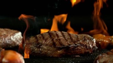 Siyah arka planda izole edilmiş ızgarada bifteğin süper yavaş çekimleri. Yüksek hızlı sinema kamerası, 1000 fps.