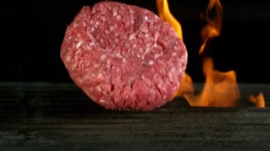 Izgaraya düşen hamburger bifteğinin süper yavaş çekimi. Yüksek hızlı sinema kamerası, 1000 fps..