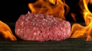 Izgaraya düşen hamburger bifteğinin süper yavaş çekimi. Yüksek hızlı sinema kamerası, 1000 fps..