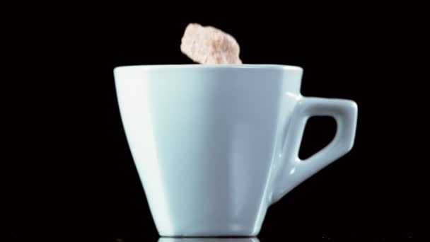 超慢的下降糖立方体进入咖啡杯 黑色背景 用高速摄像机拍摄 每秒1000英尺 — 图库视频影像