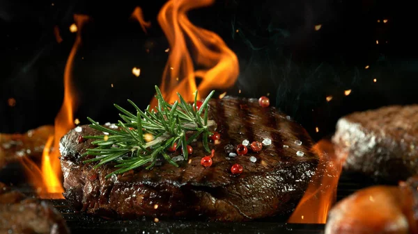 牛肉汉堡包牛排放在烤架上 切碎的肉放在有火的烤架上 黑色背景 — 图库照片