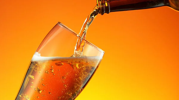 Bier Aus Der Flasche Ein Glas Auf Goldenem Hintergrund Gießen — Stockfoto