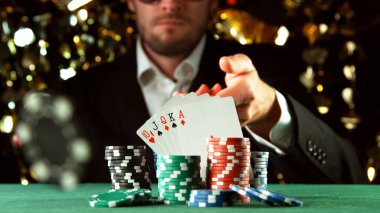 Poker oyuncusu çip atıyor. Risk oyunları, poker fişleri.