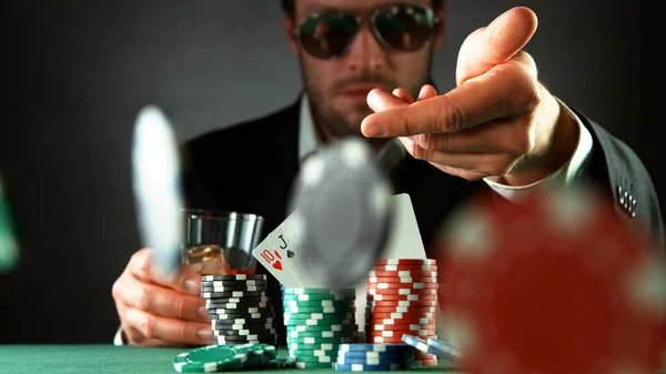 Poker player throwing chips. Concept of hazard gaming, poker chips on table