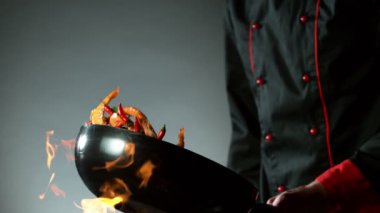 Wok Pan 'dan uçan kırmızı biber ve karideslerin süper yavaş çekimi. Yüksek hızlı sinema kamerası, 1000 fps..