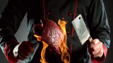 Aşçının baltayla ve ateşin üstünde biftekle çok yavaş çekimleri. Yüksek hızlı sinema kamerası, 1000 fps..