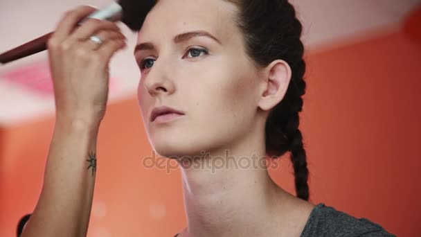 Καλλιτέχνης μακιγιάζ εφαρμογή επαγγελματικό μακιγιάζ εκ πρώτης όψεως το όμορφο νεαρή γυναίκα μοντέλο. — Αρχείο Βίντεο