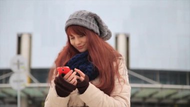 Güzel kızıl kırmızı saçlı kadın kentsel mutlu yaşam tarzı yaşayan şehir sokakları akıllı telefon teknoloji app kullanarak