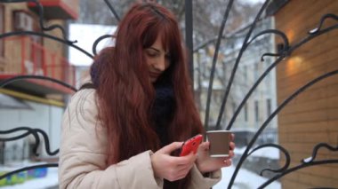 Üzerinde telefon içme kahve app açık havada şehirde gülümseyen kullanan Smartphone kız.