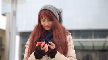 Güzel kızıl kırmızı saçlı kadın kentsel mutlu yaşam tarzı yaşayan şehir sokakları akıllı telefon teknoloji app kullanarak