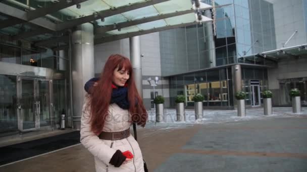 Giovane donna rossa dai capelli rossi che esce da un edificio per uffici . — Video Stock